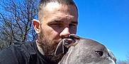 Freya joined the competition — help win amazing prizes! man, dog, beard, tattoo, outdoor, blue_sky, tree, collar, pet, happy, tongue_out, grass, sunlight, casual_clothing, animal, nature, portrait, smile, friendship, daytime