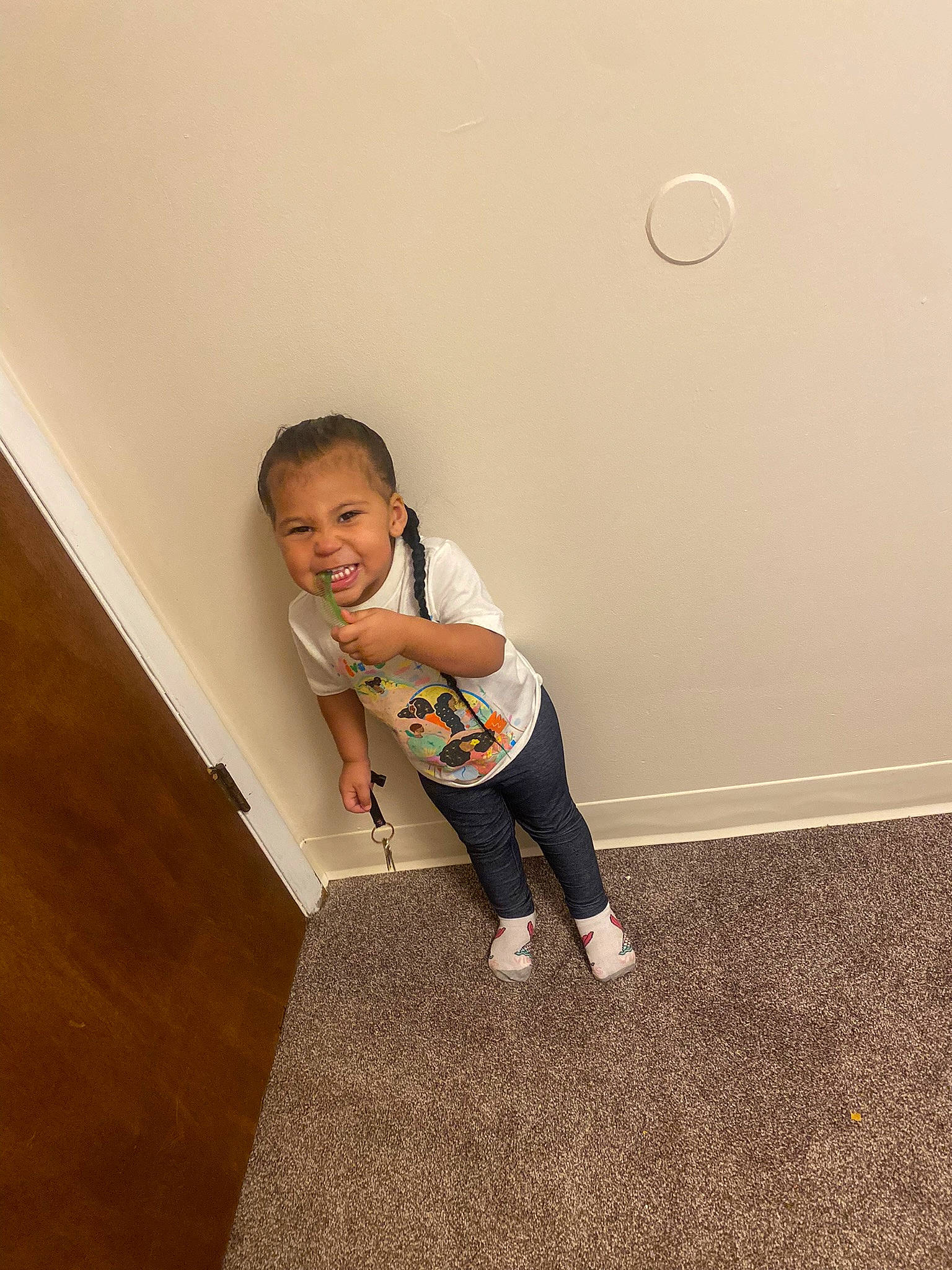 Aryana is registered to the contest to win money with this photo: baby_toddler_clothing, ceiling, door, flooring, fun, hardwood, human_leg, joy, knee, laminate_flooring, person, shoe, sleeve, smile, sneakers, sportswear, stairs, t_shirt, toddler, wood
