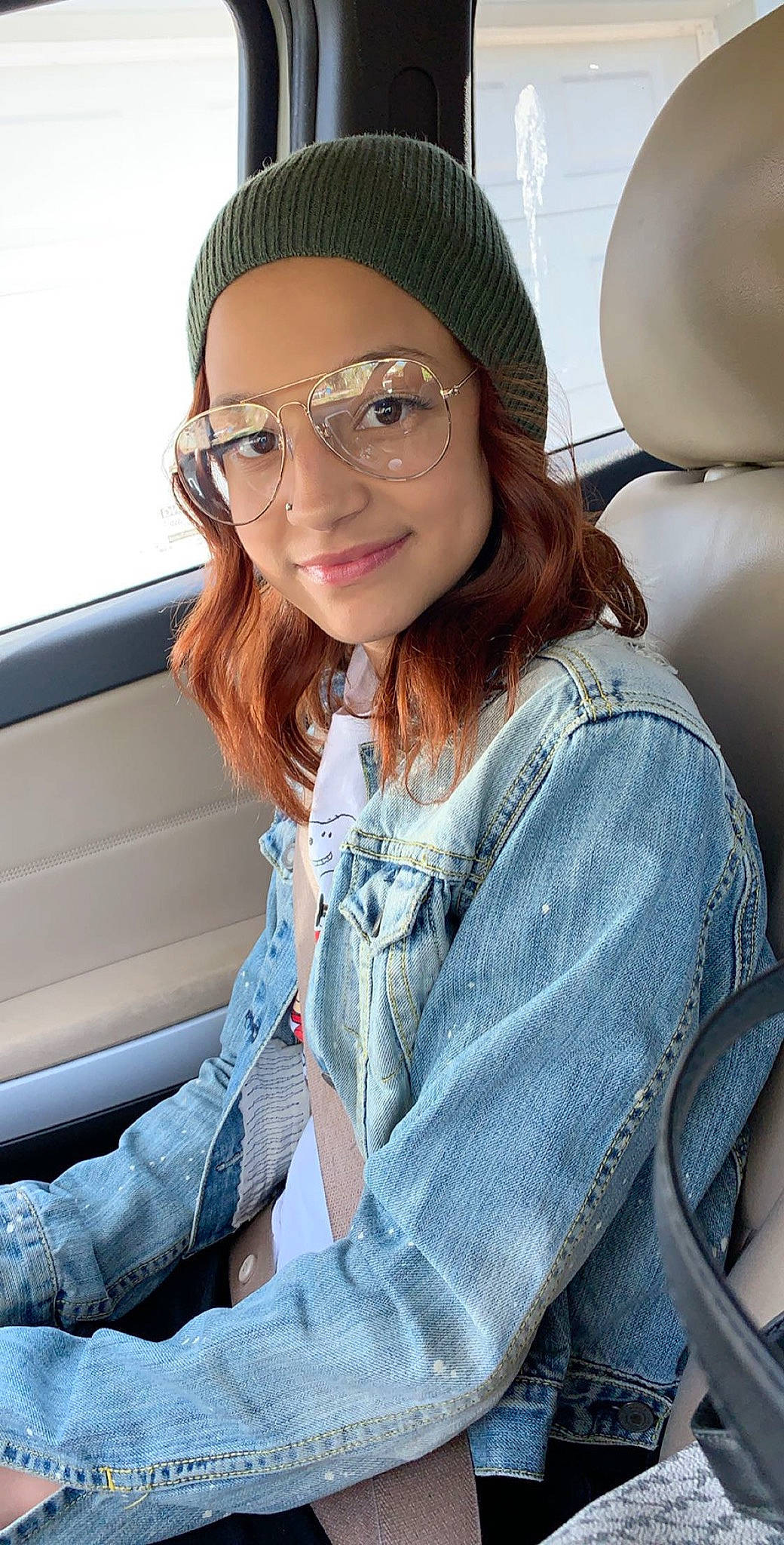 Amya is registered to the contest to win money with this photo: beanie, beauty, brown_hair, cap, cool, denim, eyewear, glasses, headgear, jeans, joy, lip, long_hair, person, sitting, smile, textile, vision_care