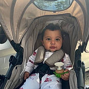 Carmelo joined the competition — help win amazing prizes! baby, child, stroller, toy, onesie, infant, seatbelt, curly_hair, cute, sitting, indoors, comfort, canopy, expression, hand, clothing, car, safety, portrait, young_child