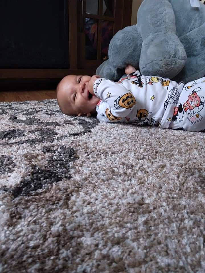 Amiri is registered to the contest to win money with this photo: baby, carmine, carpet, child, comfort, crawling, face, flooring, fun, fur, grass, happy, head, linens, person, rock, room, sitting, soil, toddler