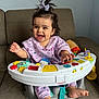 baby, child, smile, happy, toy, activity_seat, couch, indoor, foot, hand, clothing, hair_bow, infantino, play, colorful, person, seat, cute, expression, infant