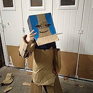 Louca a rejoint le concours — aidez-le/la à gagner de superbes lots ! child, cardboard, costume, robot, hand_gesture, indoor, door, floor, paint, blue, homemade, craft, peace_sign, box, child_in_costume, concrete_floor, white_door, casual, playful, creative