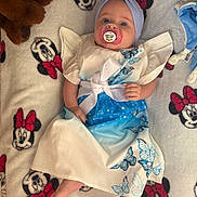Célina-Marie participe au concours pour gagner de l'argent avec cette photo : baby, pacifier, headband, dress, butterfly, blanket, minnie_mouse, plush_toy, foot, hand, face, infant, lying_down, cute, soft, blue, white, pattern, child, indoors