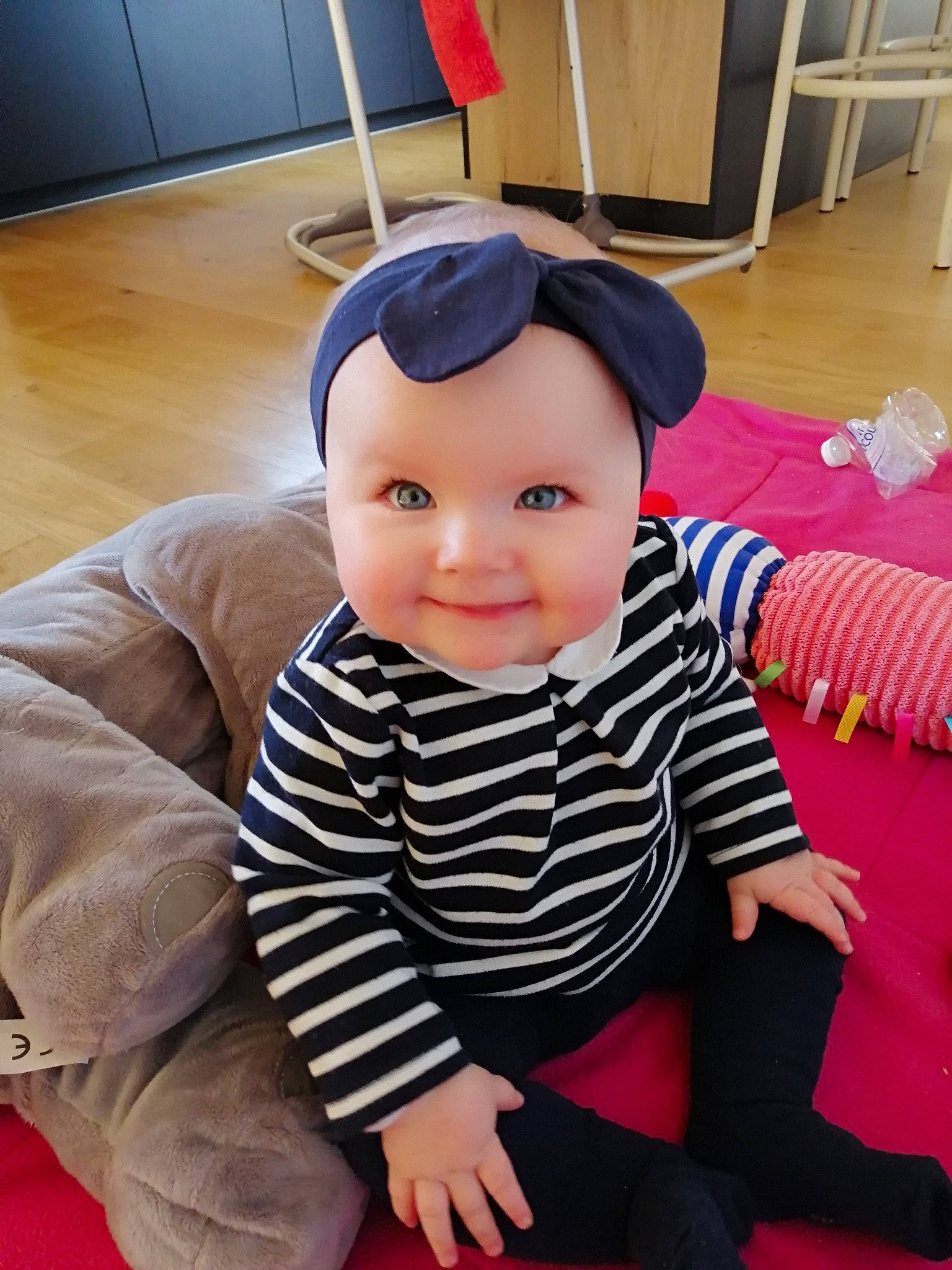 Clémence participe au concours pour gagner de l'argent avec cette photo : baby, baby_toddler_clothing, cheek, child, eye, facial_expression, floor, flooring, fun, happy, head, headwear, human_body, person, pink, room, sitting, skin, sleeve, smile
