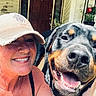 Maggie Mae joined the competition — help win amazing prizes! woman, dog, rottweiler, selfie, portrait, smiling, happy, outdoor, porch, front_door, house, plants, hat, baseball_cap, black_and_tan, large_dog, pet, collar, teeth, sunlight
