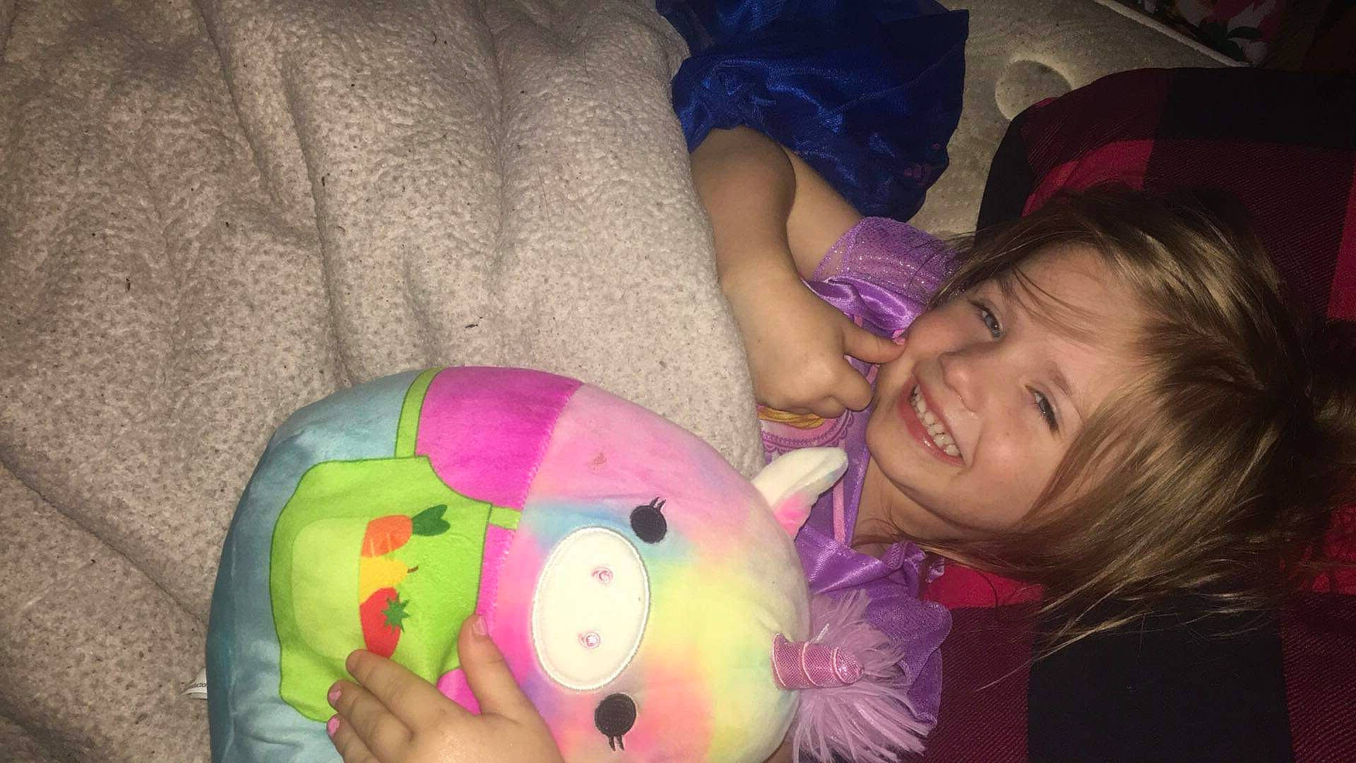 Raelynn is registered to the contest to win money with this photo: cheek, child, eye, facial_expression, finger, fun, happy, head, iris, joy, mouth, nose, people, person, pink, purple, skin, smile, stuffed_toy, textile