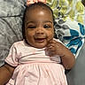 baby, child, smiling, pink_dress, bow, lying_down, blanket, patterned_blanket, happy, cute, infant, portrait, indoor, person, toddler, hand, face, headwear, clothing, skin