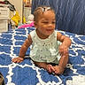 Aleiyah joined the competition — help win amazing prizes! baby, child, infant, bed, bedspread, blue, white, dress, pattern, hair_beads, braids, indoor, mirror, clothing, candle, furniture, smiling, sitting, person, room
