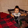 toddler, child, playpen, bed, blanket, quilt, indoor, smiling, curly_hair, person, clothing, furniture, happy, baby, face, head, hands, fabric, blanket_pattern, cozy