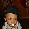 baby, black_cap, cap, cap_backwards, child, clothing, cute, expression, floor, headwear, indoor, kid, pacifier, person, shirt, spiderman, squinting, toddler, wooden_floor, young_child