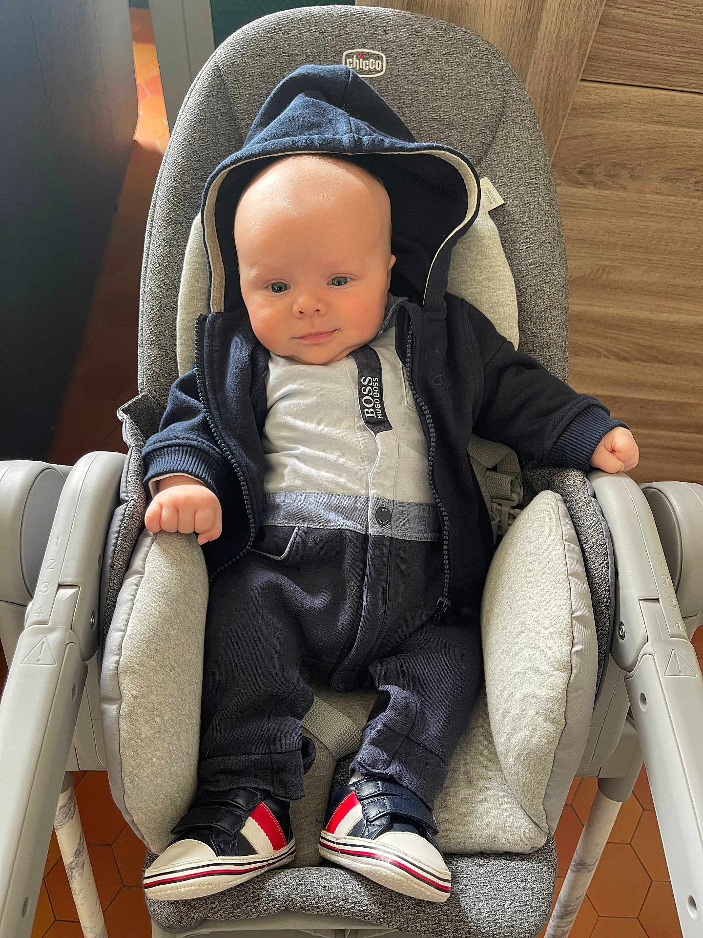 Andréas participe au concours pour gagner de l'argent avec cette photo : baby, infant, hoodie, sneakers, baby_seat, chicco, clothing, cute, indoor, child, person, footwear, casual_wear, seated, comfort, smile, small_hands, face, headwear, fashion