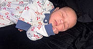 Kylo is registered to the contest to win money with this photo: baby, blanket, child, clothing, cozy, cute, face, hand, indoor, infant, newborn, onesie, peaceful, person, portrait, relaxation, resting, sleeping, soft, star_pattern