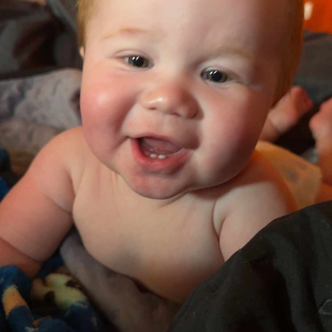 Carson is registered to the contest to win money with this photo: baby, babylaughing, bodypart, couch, face, finger, furniture, hand, happy, head, indoors, laughing, mouth, newborn, person, photography, portrait, sitting, smile, teeth