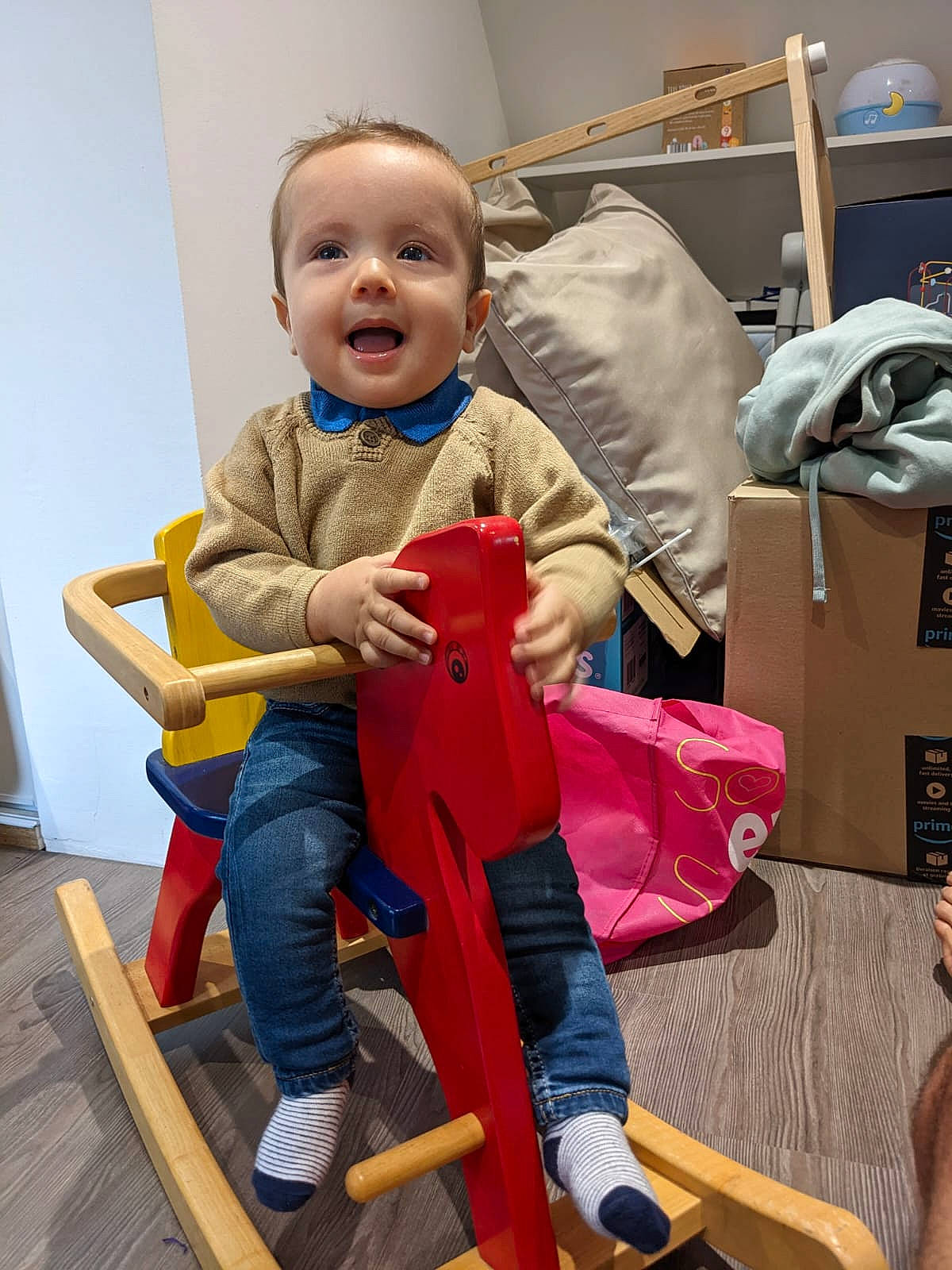 Loris a rejoint le concours — aidez-le/la à gagner de superbes lots ! baby, baby_toddler_clothing, bag, child, comfort, flooring, fun, happy, hardwood, luggage_and_bags, person, play, room, sitting, smile, t_shirt, toddler, travel, wood