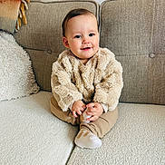 Leo joined the competition — help win amazing prizes! baby, child, couch, sweater, beige, smile, home, cozy, furniture, sitting, infant, cute, warm, blanket, cushion, portrait, person, indoor, comfortable, happy