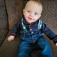 Reggie is registered to the contest to win money with this photo: armchair, baby, bodypart, chair, clothing, coat, couch, face, finger, furniture, hand, happy, head, jacket, jeans, pants, person, photography, portrait, sitting