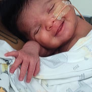 Zion joined the competition — help win amazing prizes! baby, infant, smiling, nasal_tube, medical_tape, blanket, animal_print, sleeping, person, closeup, cute, newborn, resting, hand, face, healthcare, child, indoor, comfort, care