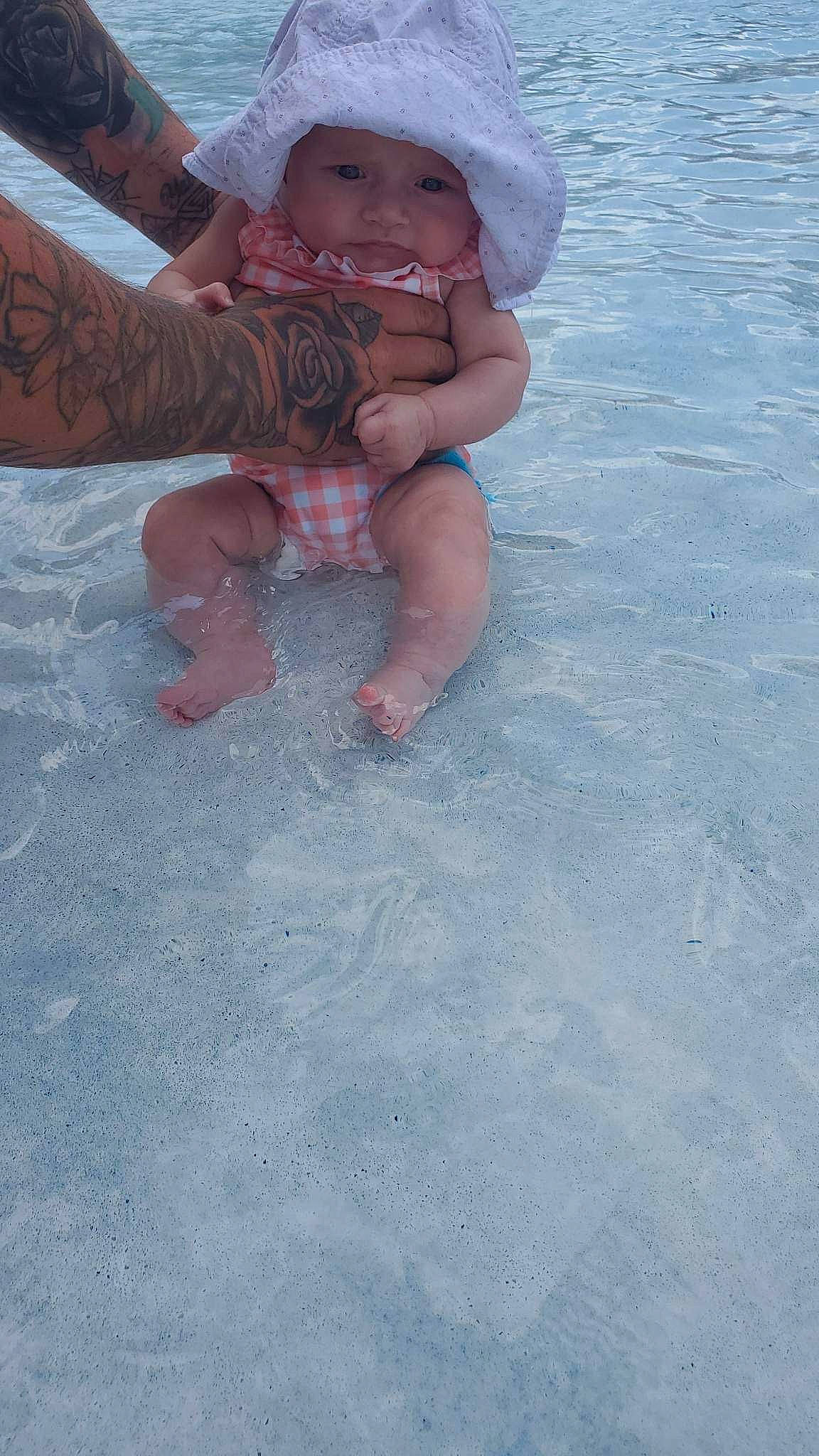 Annalise is registered to the contest to win money with this photo: barefoot, child, flooring, foot, fun, happy, hat, headwear, human_leg, leg, leisure, nail, person, recreation, sand, shorts, sun_hat, thigh, thumb, toddler