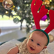 Rory joined the competition — help win amazing prizes! baby, infant, child, smile, red_antenna_headband, holiday, christmas_tree, ornaments, decorations, festive, cute, blanket, soft, indoors, portrait, happy, holiday_season, holiday_clothing, holiday_spirit, celebration