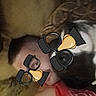animal, brown_couch, casual, closeup, couch, decorative_pillow, disguise, dog, face_overlay, funny, glasses_overlay, home, indoor, person, pet, red_shirt, relaxation, resting, selfie, tattoo