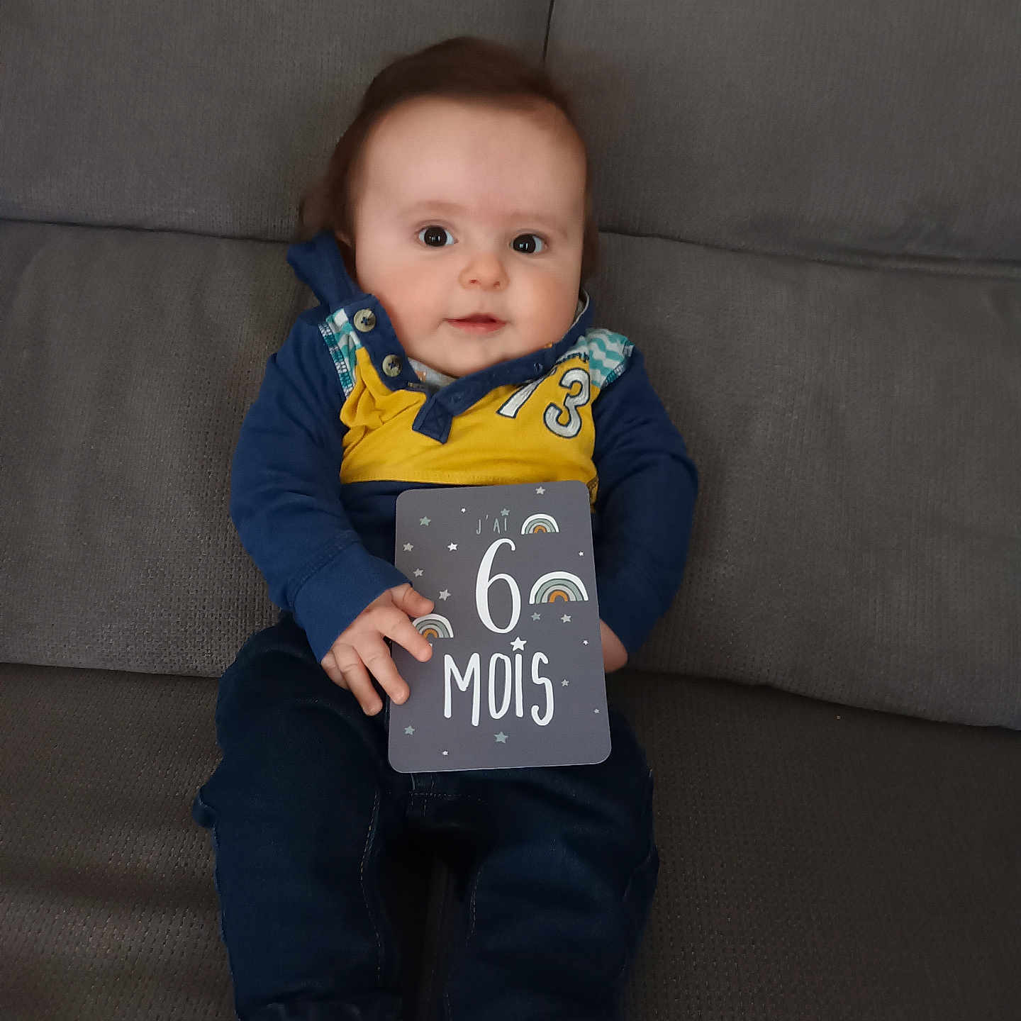Maël participe au concours pour gagner de l'argent avec cette photo : baby, bodypart, clothing, coat, couch, face, finger, footwear, furniture, hand, head, hosiery, jeans, pants, person, photography, portrait, shoe, sitting, sock