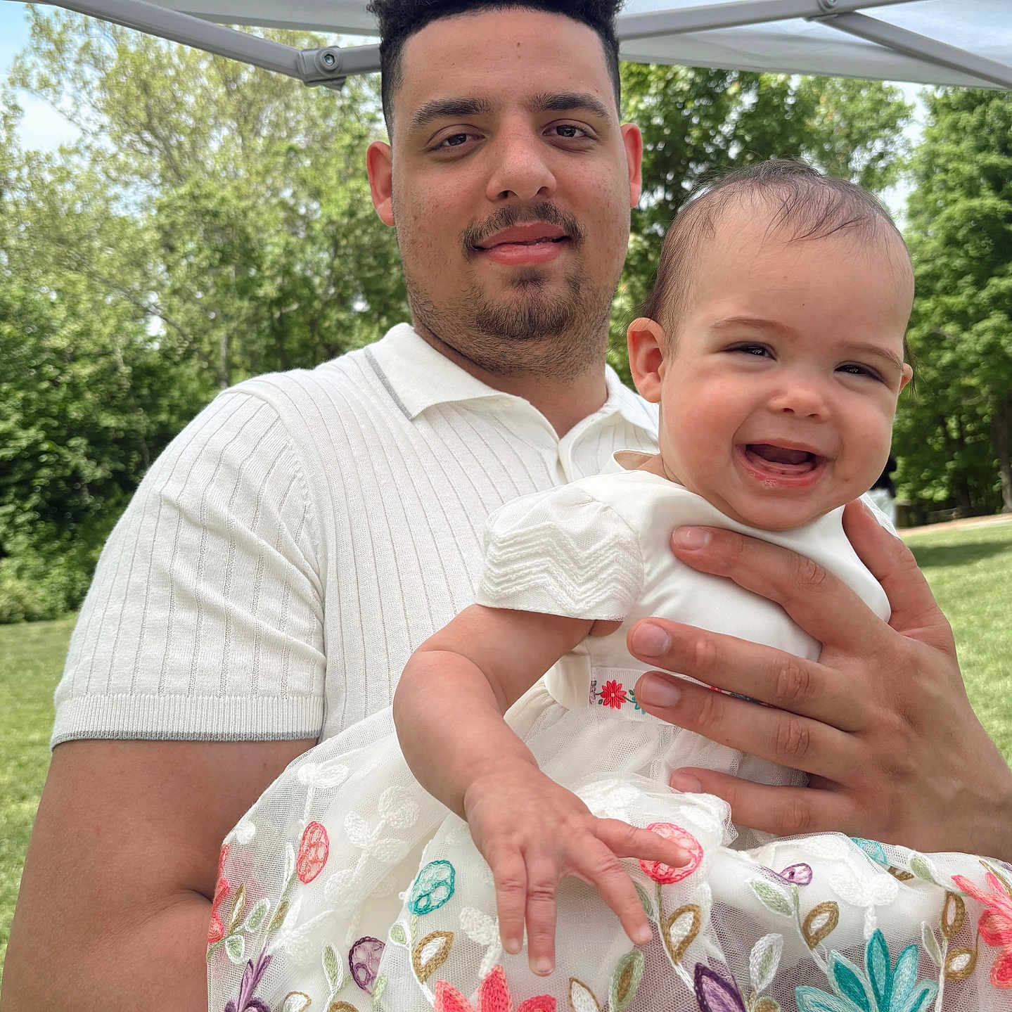 Esmaei joined the competition — help win amazing prizes! baby, canopy, casual, child, daytime, dress, embroidery, family, floral, greenery, happy, holding, man, nature, outdoor, park, people, portrait, smile, sunny