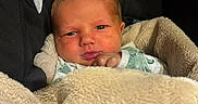 Jimmy is registered to the contest to win money with this photo: newborn, baby, infant, child, portrait, face, eyes, lips, hand, sleeping, awake, car_seat, blanket, plush, cozy, sitting, indoors, close_up, photography, safe