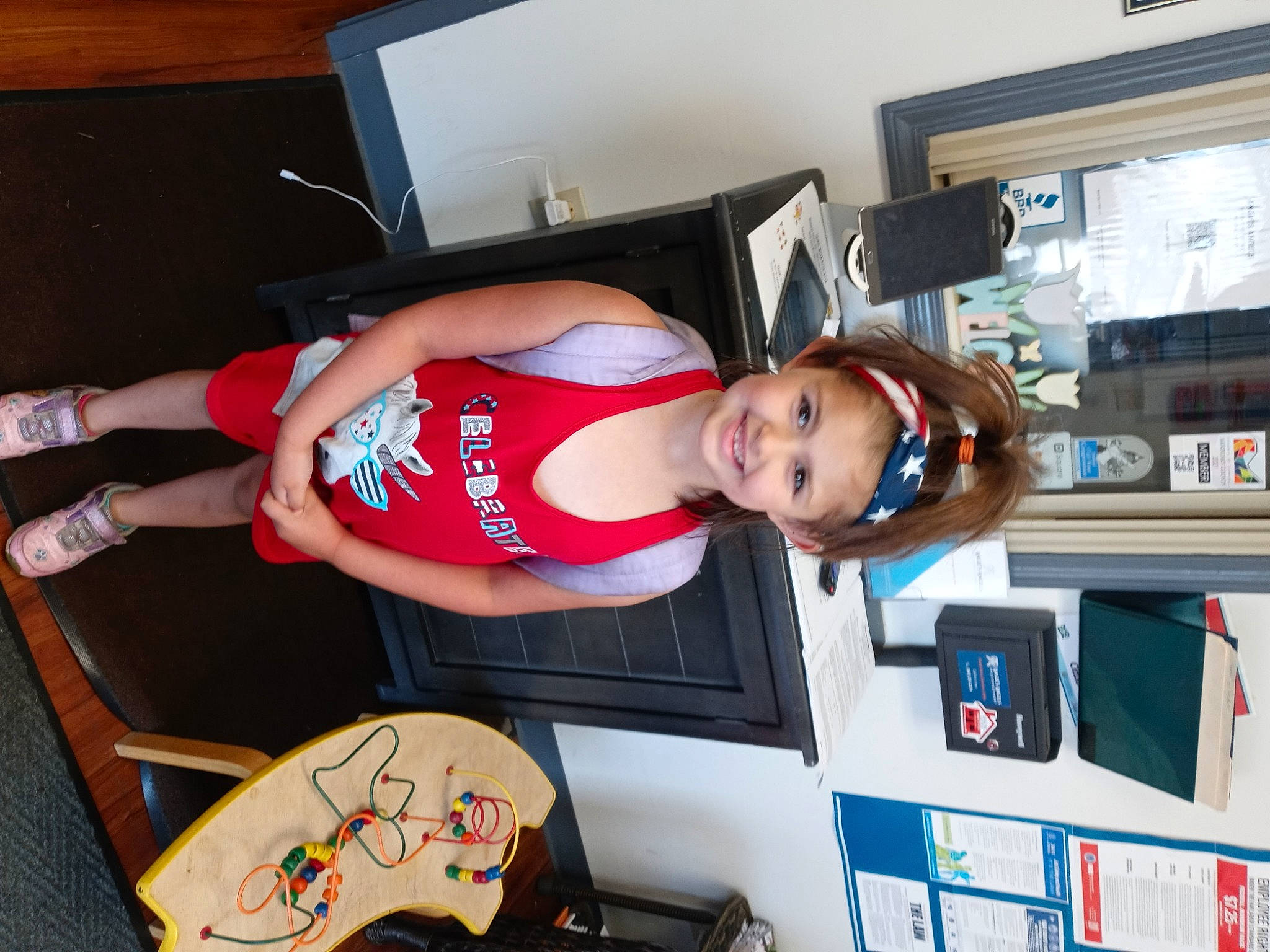 Riley is registered to the contest to win money with this photo: child, elbow, fun, hat, headwear, human_leg, joy, knee, machine, person, room, shelf, shorts, smile, sportswear, t_shirt, thigh, toddler