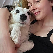 Grizou a rejoint le concours — aidez-le/la à gagner de superbes lots ! woman, dog, pet, portrait, smile, face, cuddling, black_clothing, earrings, indoor, closeup, fur, light_skin, happy, relaxed, bed, blanket, casual, companion, affection
