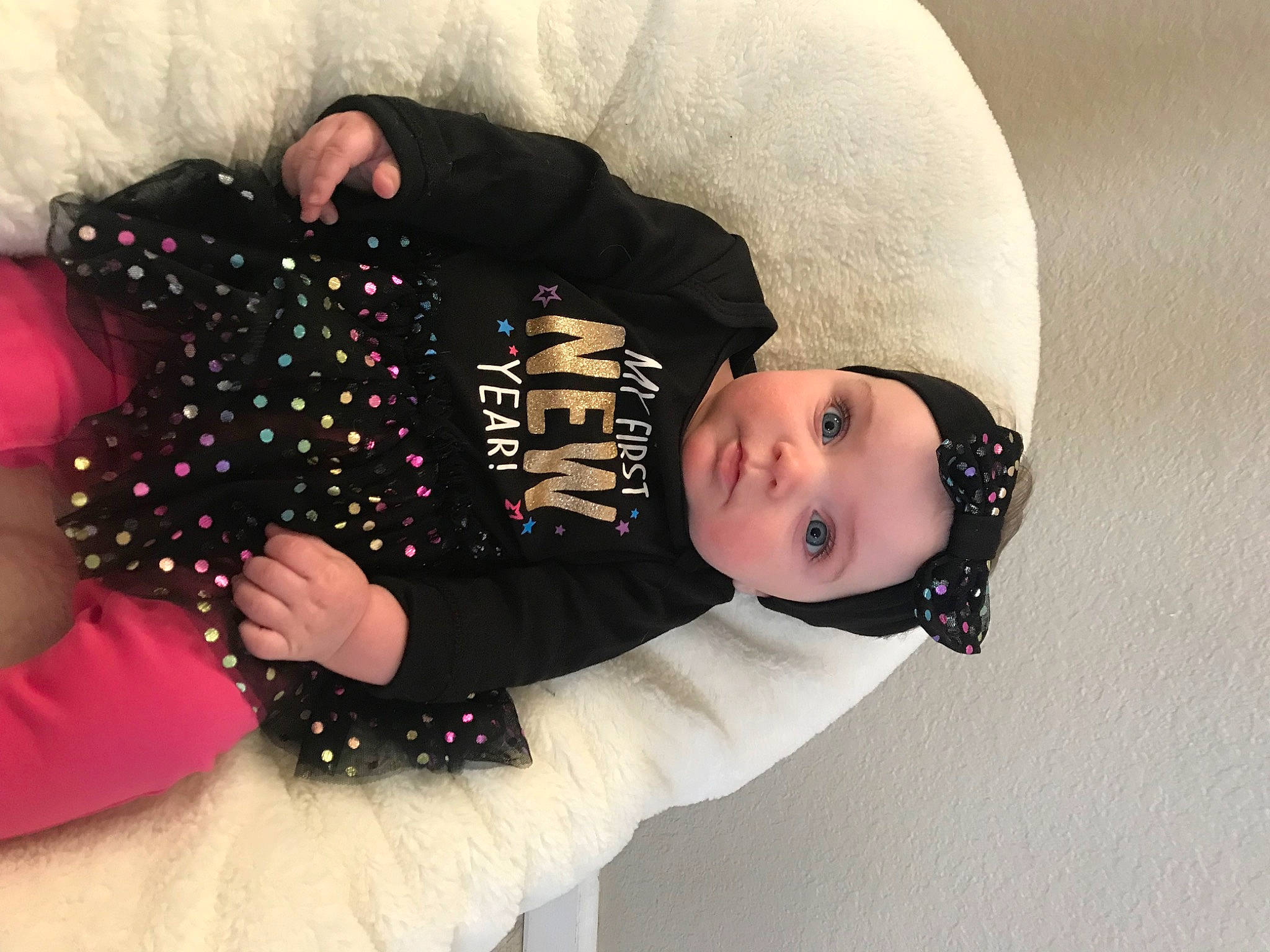 Lila is registered to the contest to win money with this photo: arm, baby, baby_toddler_clothing, black_hair, cap, child, comfort, fashion_accessory, flash_photography, fur, hat, headgear, headwear, human_body, pattern, person, sitting, skin, sleeve, textile