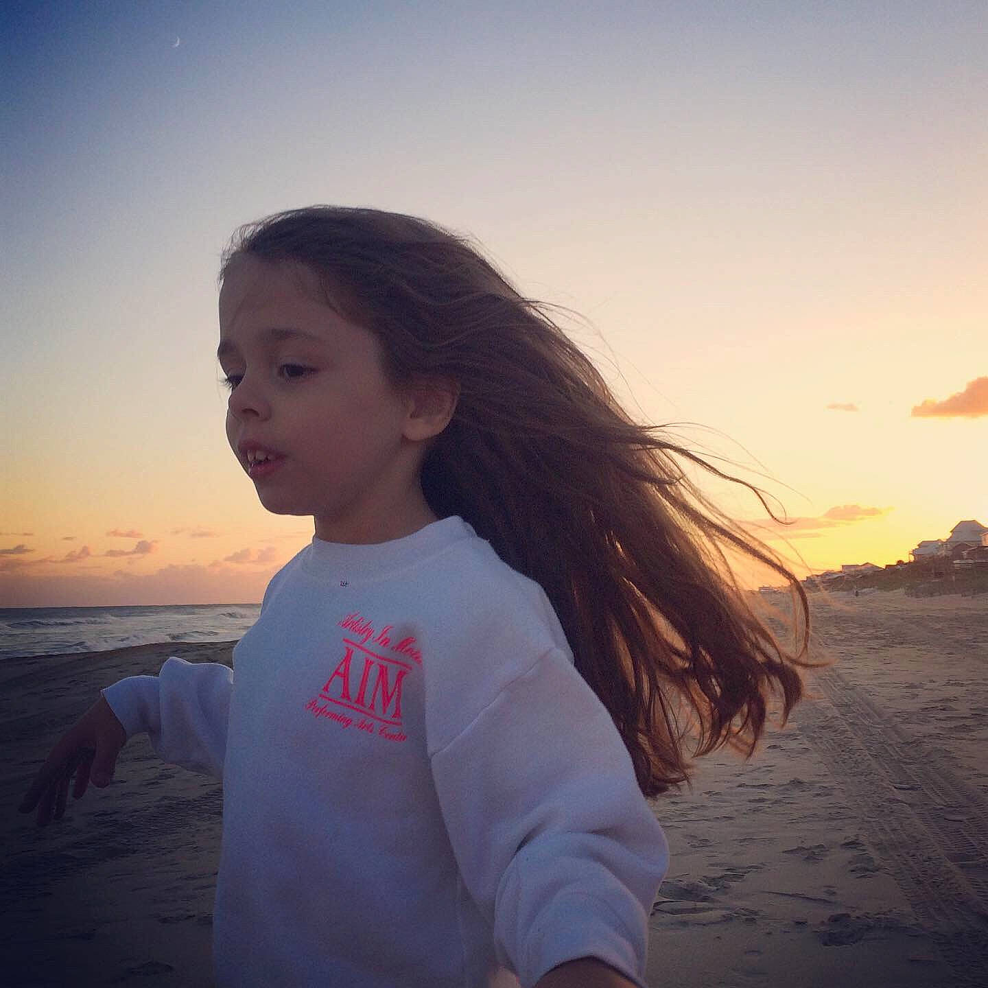 Maia is registered to the contest to win money with this photo: beach, blond, calm, cloud, dusk, flash_photography, fun, grass, happy, horizon, landscape, leisure, people_in_nature, person, sky, sunlight, sunrise, sunset, t_shirt, travel