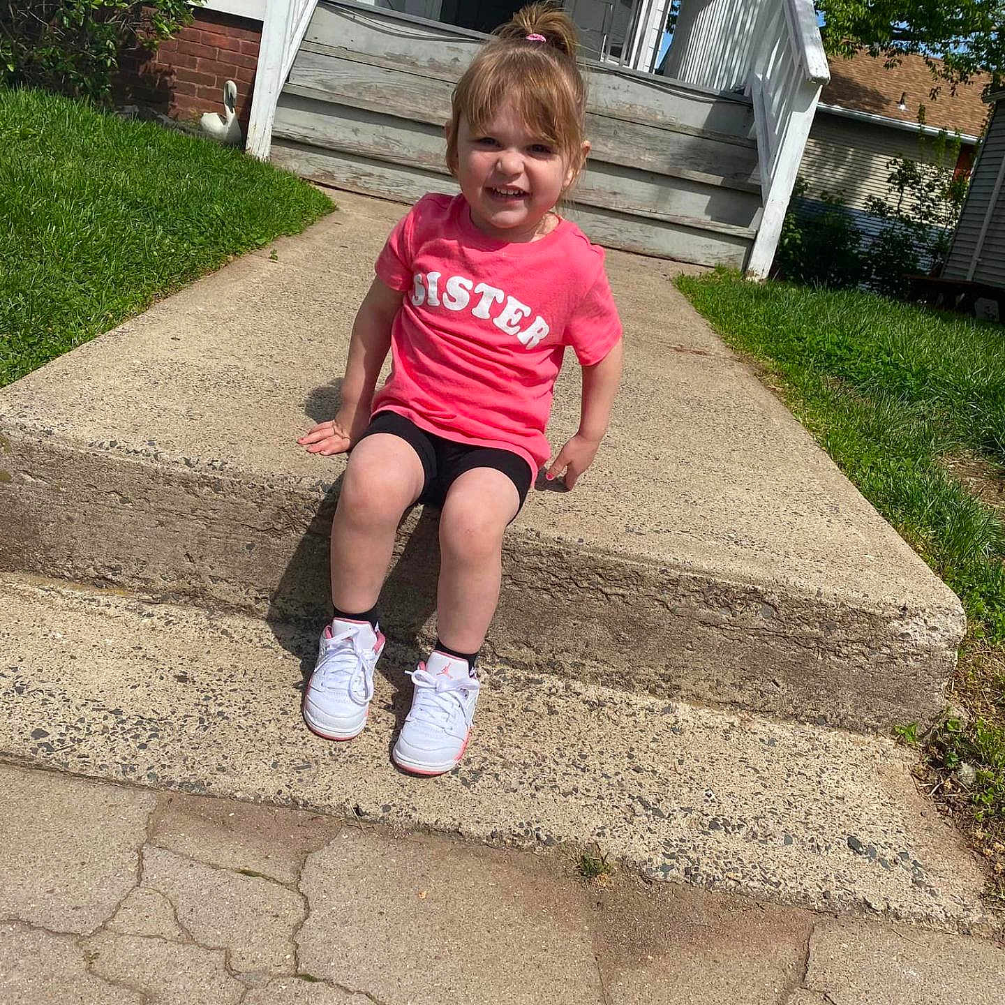 Karley is registered to the contest to win money with this photo: backyard, city, clothing, face, footwear, grass, head, nature, outdoors, path, person, photography, plant, portrait, road, shoe, shorts, sitting, summer, yard