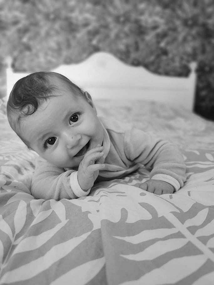 Loïs participe au concours pour gagner de l'argent avec cette photo : baby, baby_toddler_clothing, black_and_white, cheek, comfort, eye, face, flash_photography, grey, happy, head, human, iris, mammal, nose, person, skin, smile, style, vertebrate