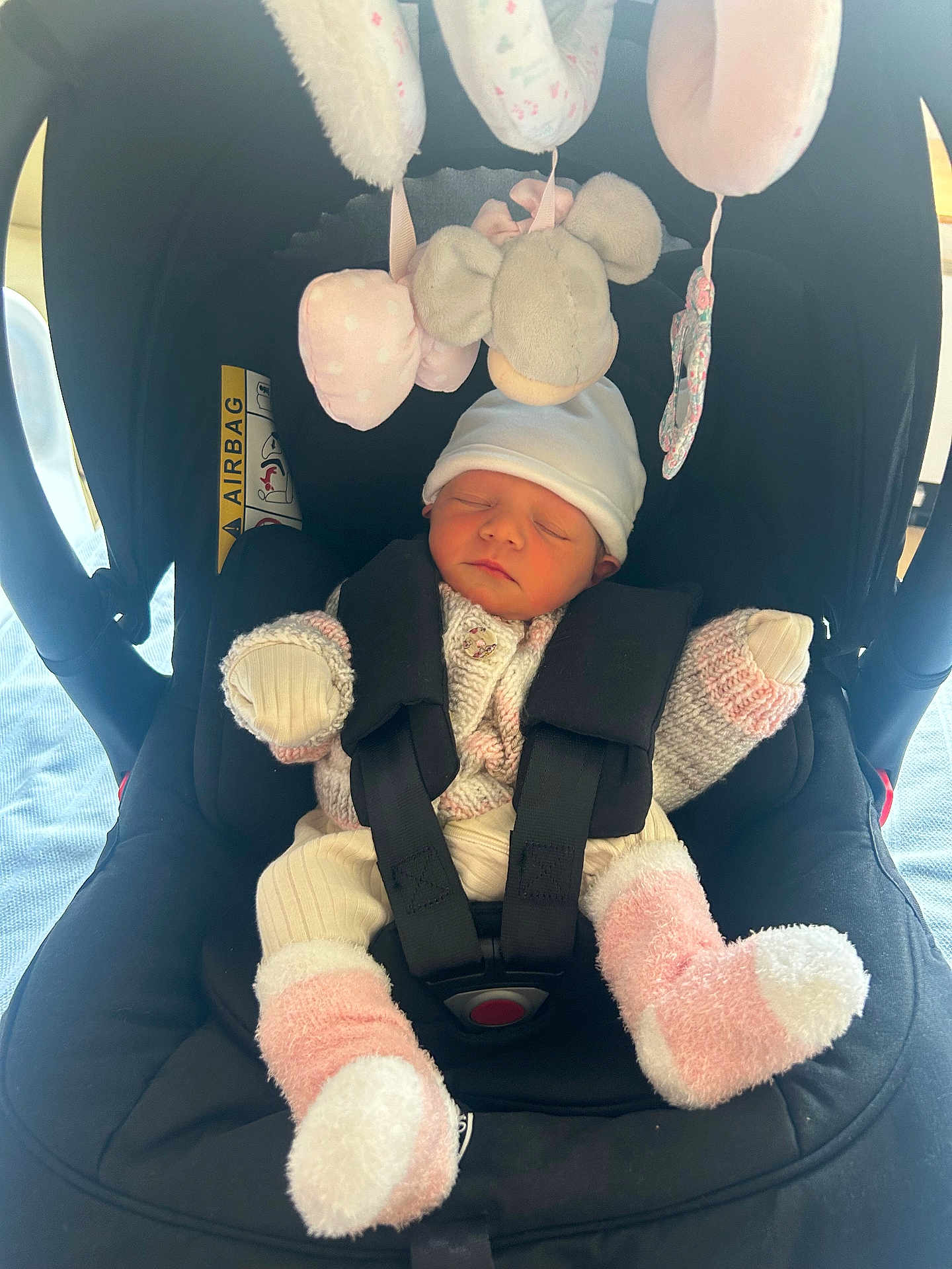 Aubrey is registered to the contest to win money with this photo: newborn, baby, car_seat, sleeping, knitwear, hat, socks, soft_toys, mobile, infant, child, seatbelt, cozy, indoor, cute, comfort, peaceful, person, baby_clothes, resting