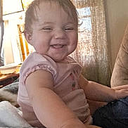 Madilynn joined the competition — help win amazing prizes! baby, child, smiling, happy, indoor, lamp, blanket, curtain, person, toddler, clothing, hand, face, furniture, cozy, portrait, sitting, cute, infant, home