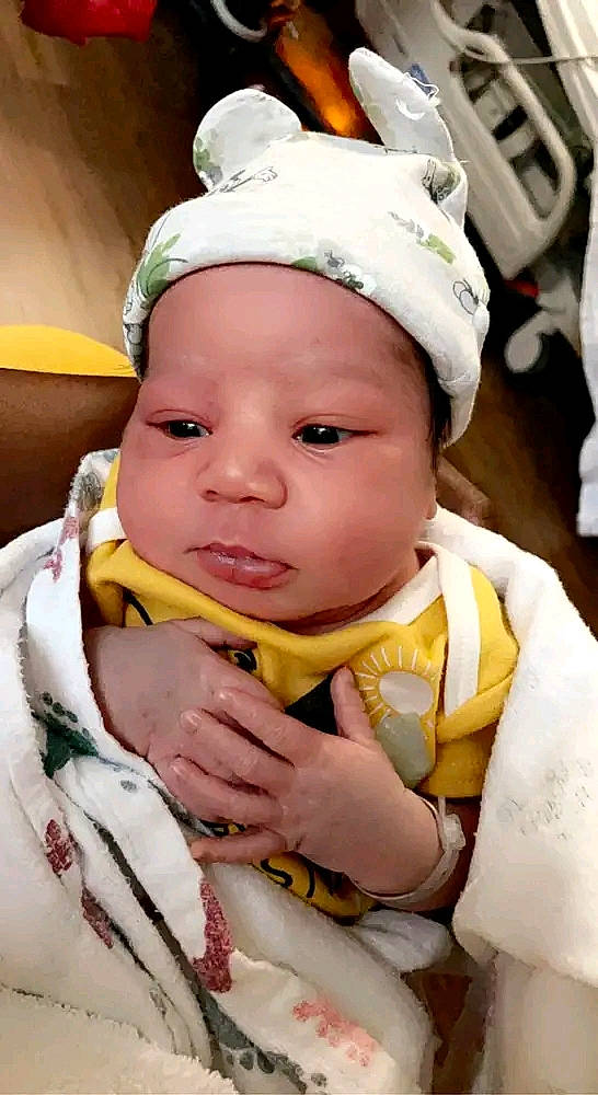 Casey is registered to the contest to win money with this photo: baby, baby_products, baby_toddler_clothing, cap, cheek, child, costume, costume_hat, facial_expression, fashion_accessory, fun, grass, happy, hat, headwear, jewellery, pattern, person, sitting, skin