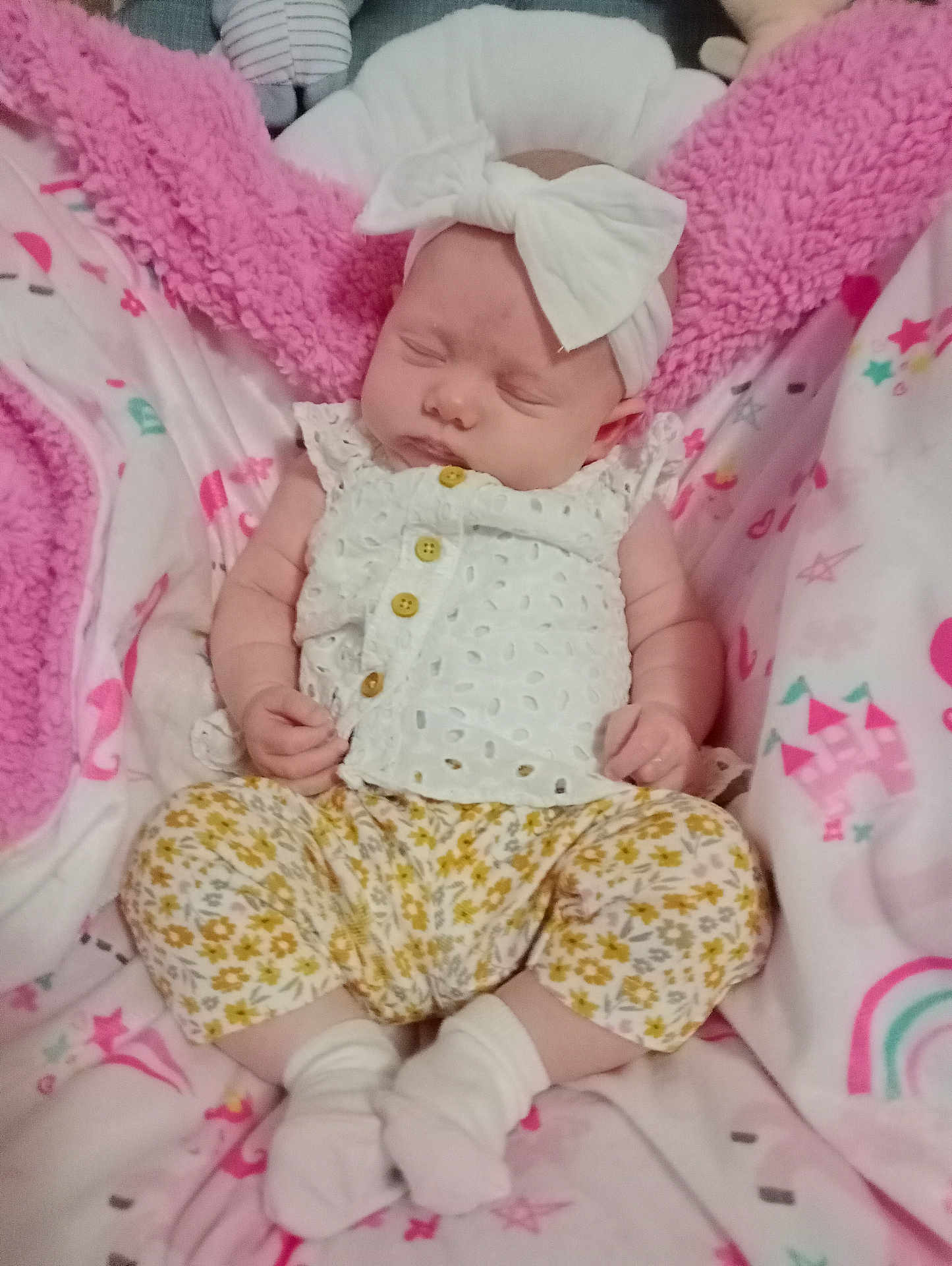 Maelee is registered to the contest to win money with this photo: baby, sleeping, headband, bow, white_clothing, floral_pants, socks, blanket, pink_blanket, soft_texture, infant, child, cute, resting, indoors, cozy, newborn, patterned_clothing, peaceful, portrait