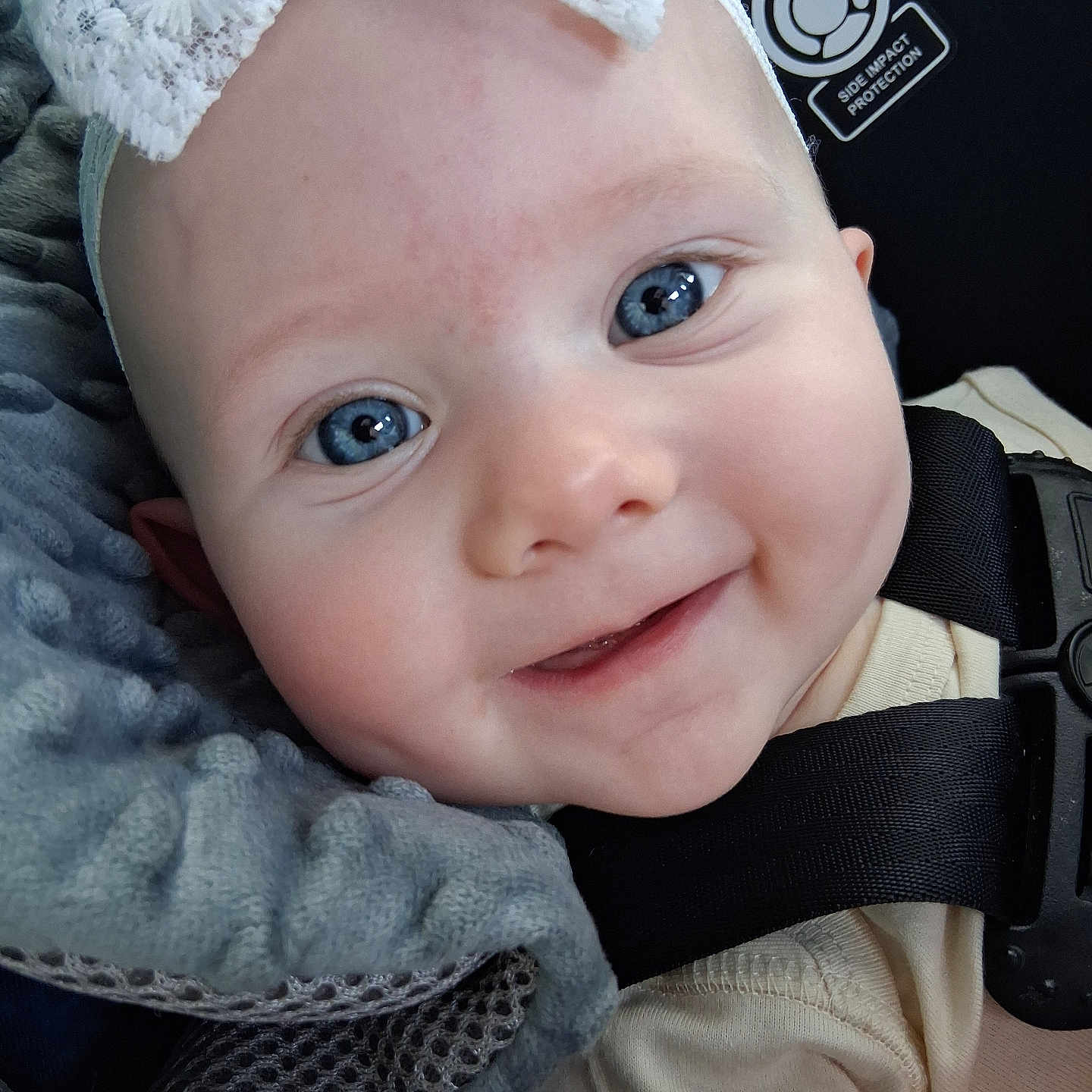 Maelee is registered to the contest to win money with this photo: baby, blue_eyes, smile, headband, lace, infant, close_up, face, car_seat, blanket, clothing, cute, child, happy, person, portrait, seatbelt, soft_texture, young, baby_girl