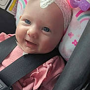 Maelee is registered to the contest to win money with this photo: accessory, baby, blue_eyes, bow, car_interior, car_seat, chubby_cheeks, closeup, headband, infant, lace_headband, pink_clothing, plush, portrait, rainbow_pattern, rosy_cheeks, safety_label, seatbelt, smiling, toy