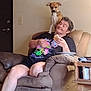 brown, casual, chair, couch, curious, dog, door, furniture, home, indoor, light_switch, person, pet, plate, relaxing, sandwich, short_hair, shorts, table, tshirt