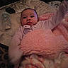 Harmony is registered to the contest to win money with this photo: baby, infant, child, portrait, face, eyes, awake, blanket, pink_blanket, clothing, onesie, bed, bedding, pillow, pacifier, remote_control, indoor, bedroom, cozy, sitting