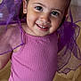 toddler, child, smiling, pink_top, white_tights, purple_fabric, indoor, wooden_floor, portrait, playful, happy, small_earrings, cute, young_child, girl, closeup, bright_eyes, fashion, person, cheerful