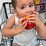 Sloane is registered to the contest to win money with this photo: child, toddler, shopping_cart, apple, grocery_store, eating, food, snack, cute, girl, casual_clothing, shorts, tank_top, earrings, hair_tied, supermarket, candy, colorful, curious, portrait