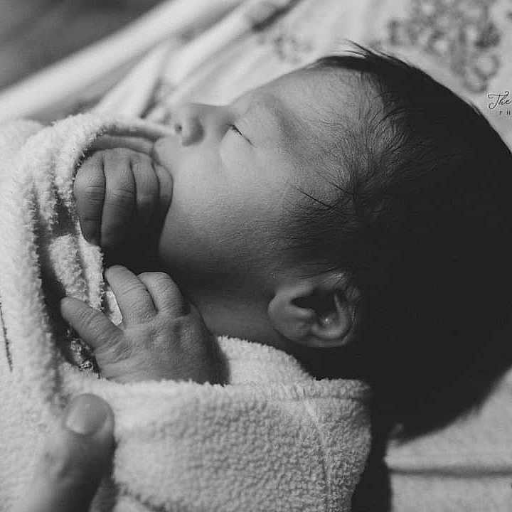 Saint is registered to the contest to win money with this photo: baby, bed, blanket, bodypart, cradle, face, finger, furniture, hand, happy, head, newborn, person, photography, portrait, quilt, sleeping, smile, towel