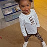 Omarianna is registered to the contest to win money with this photo: toddler, child, girl, pigtails, bows, white_shirt, patterned_leggings, sneakers, carpet, indoor, television, plastic_drawers, room, standing, smiling, cute, posing, floor, hand, nail_polish