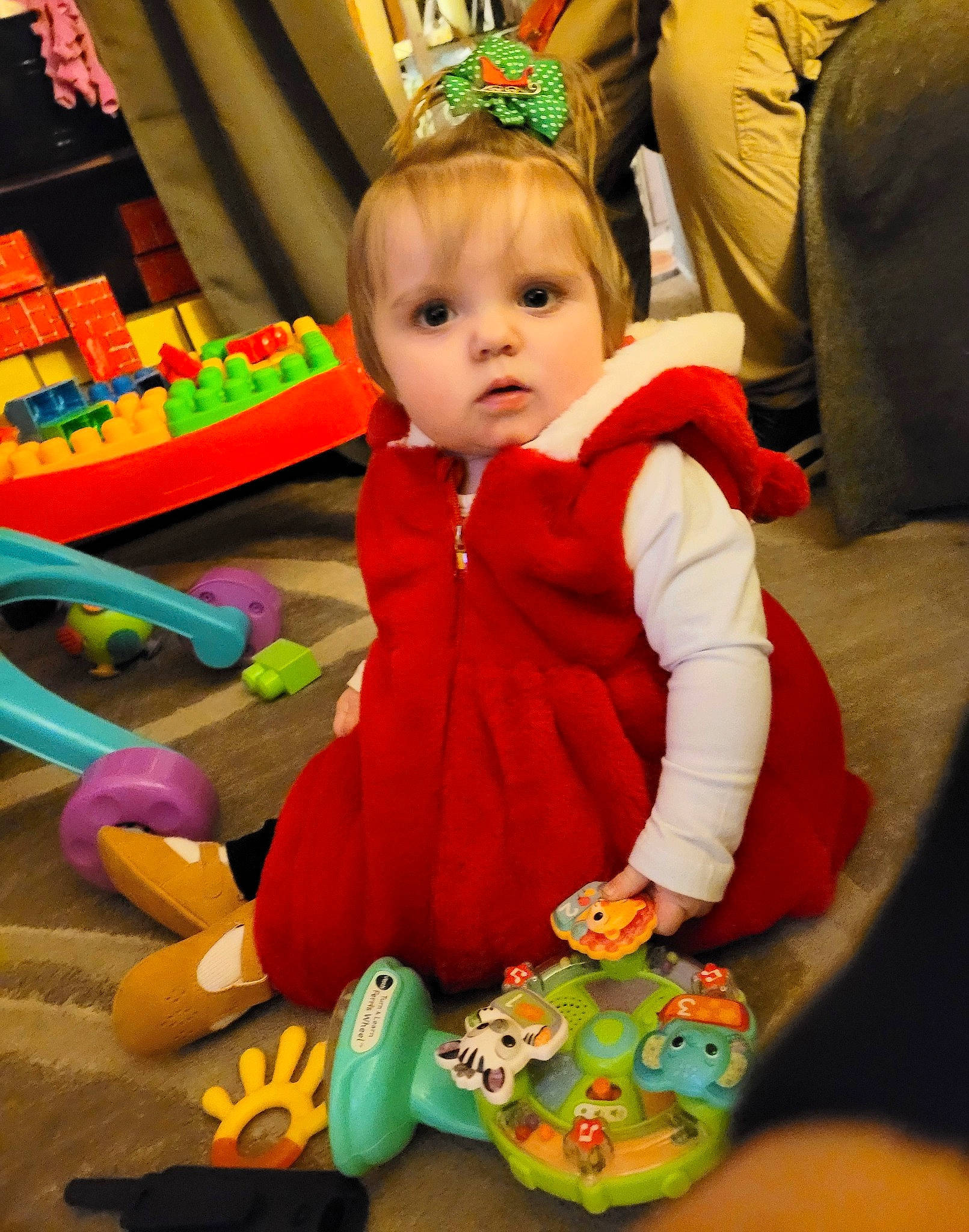 Esmeray is registered to the contest to win money with this photo: baby, baby_toddler_clothing, baby_toys, child, event, flooring, fun, green, happy, hat, holiday, lap, person, play, product, room, sitting, stuffed_toy, toddler, toy