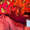 Hazel is registered to the contest to win money with this photo: kitten, cat, animal, pet, sitting, portrait, indoors, bedroom, blanket, pillow, bedding, hello_kitty, pink, red, cozy, cute, fur, whiskers, phone, low_light