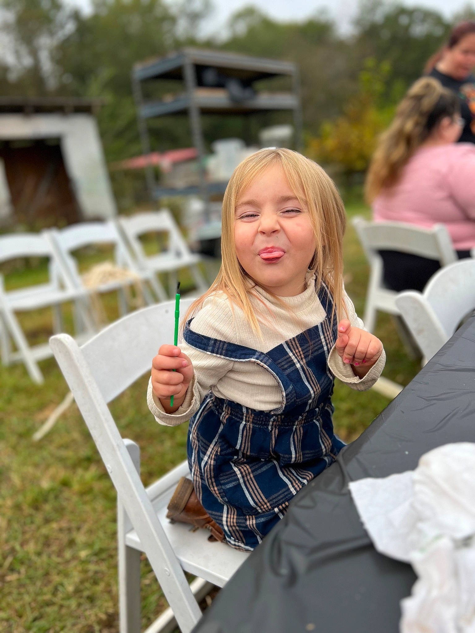 Stella joined the competition — help win amazing prizes! blurred, chair, child, event, fun, furniture, grass, happy, leisure, outdoor_furniture, outdoor_table, person, recreation, sitting, summer, t_shirt, table, tableware, tartan, toddler