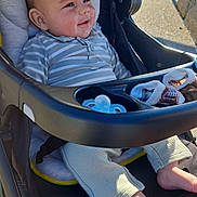 Logan participe au concours pour gagner de l'argent avec cette photo : baby, stroller, child, outdoor, sunlight, smiling, face, clothing, pacifier, socks, footwear, seat, happy, infant, person, portrait, relaxing, daylight, casual, comfort